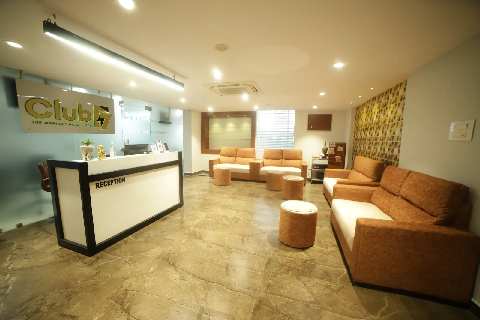 Reception desk with the Club F7 sign and an orange sofa lounge behind it